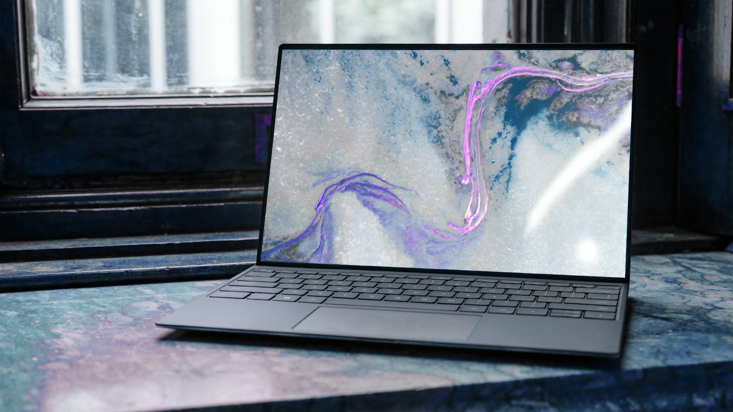 Laptop displaying abstract art on a textured surface.